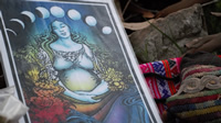 Una imagen dibujada de una mujer embarazada sosteniendo su vientre, con las fases de la luna sobre su cabeza.