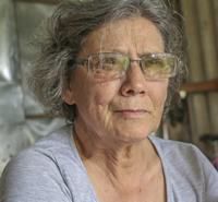 Primer plano de Delfa, una mujer de pelo corto, canoso y anteojos de marco fino color gris metal.
