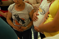 Varias mujeres embarazadas tomándose el vientre; en medio de ellas está Delfa que también sostiene su vientre con las dos manos.