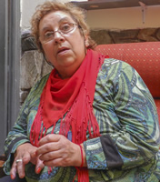 Primer plano de Myriam, sentada en un sillón, hablando.